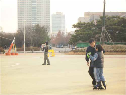 광장에서 연을 날리는 아버지와 아들 